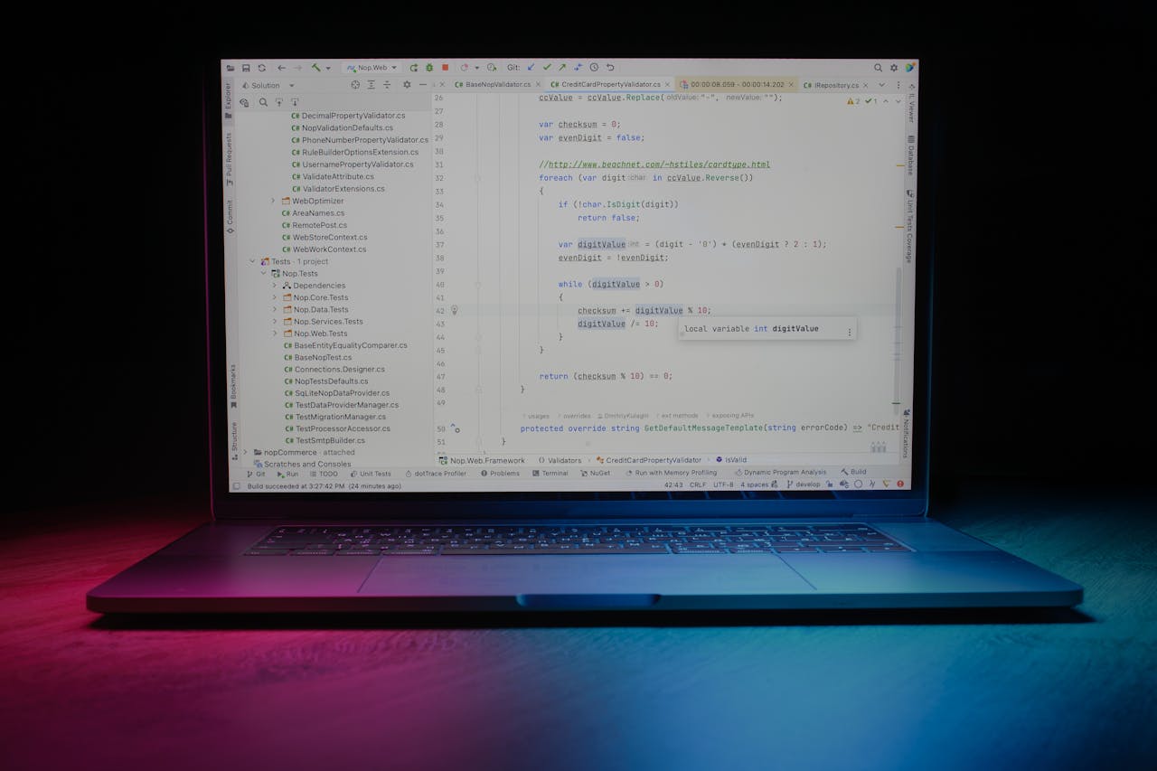 Close-up of a laptop showing code editor under vibrant lighting, ideal for tech themes.